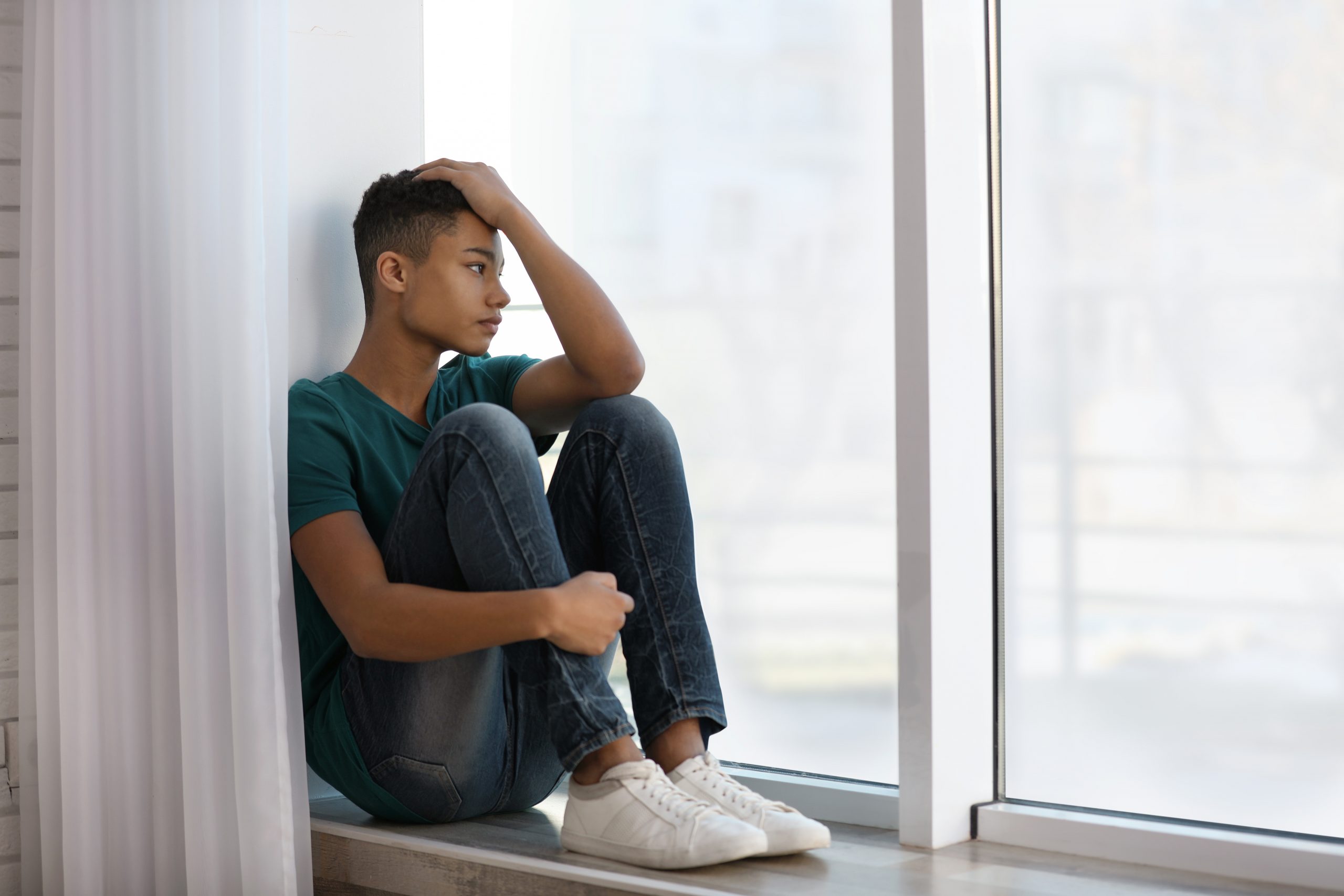 Upset,African-american,Teenage,Boy,Sitting,Alone,Near,Window